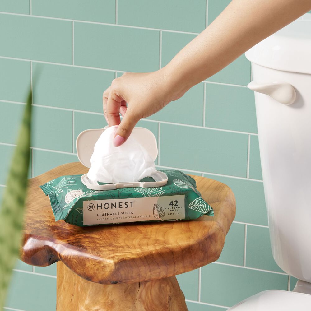hand pulling out flushable wipes from package